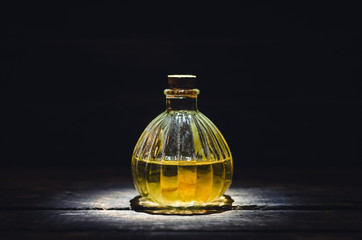 Magic potion or orange essential oil in the bottle on the table.