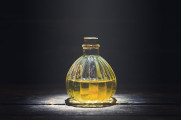 Magic potion or orange essential oil in the bottle on the table.