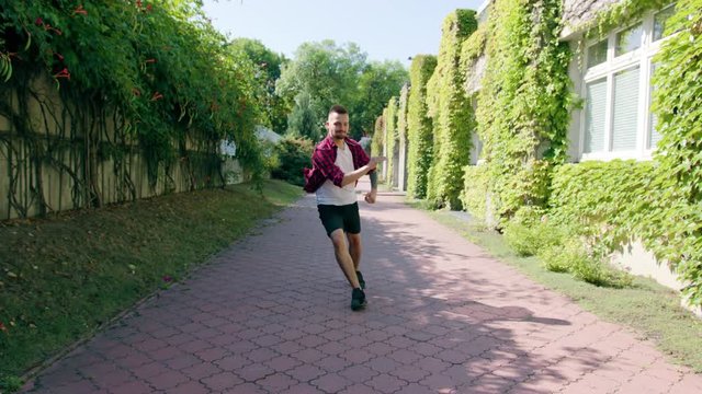 A young man dressed in dancing in the street. Long shot. Dolly shot