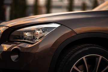 Headlights and hood of sport brown car