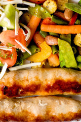 Macro photo of sausages and fried vegetables