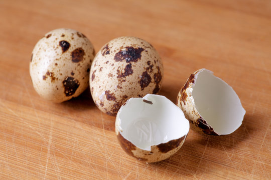 Quail eggs and eggshell on woody background, healthy food concept