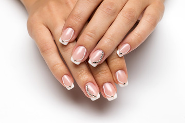 Wedding French manicure with crystals and drawings on long square nails on a white background closeup
