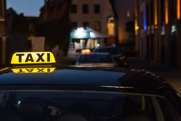 illuminated sign taxi on the roof of the car