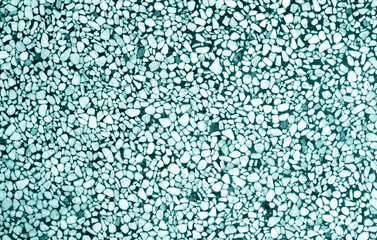 Wall made of small stones in cyan tone.