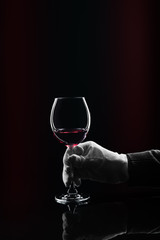 Fototapeta na wymiar Hand in white glove hold wine glass