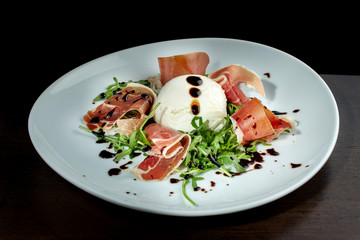 Salad with bacon and soft cheese. It is decorated with sauce.