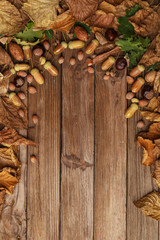 Autumn composition with dry leaves and ripe pumpkins on a wooden table. Top view. Copy space