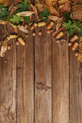 Autumn composition with dry leaves and ripe pumpkins on a wooden table. Top view. Copy space