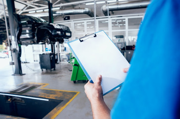Mechanic with a order board at the service station
