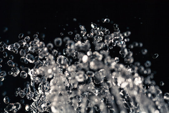 Water drops levitation on black background and do it against law of physics