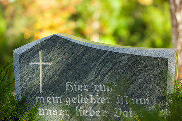 Tombstone with Inscription "Hier ruht mein geliebter Mann, unser lieber Vater (Here lies my beloved Husband, our dear Father") on a Cemetery in Berlin