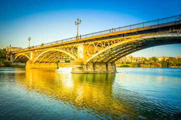 Fototapeta na wymiar Triana Bridge, the oldest bridge of Seville, Spain, toned