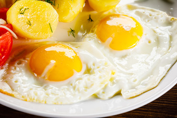 Fried eggs, boiled potatoes and vegetables