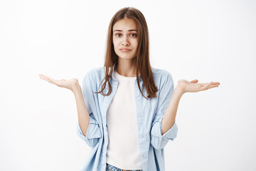 Woman has no clue what do. Unaware and clueless attractive feminine girl with brown hair in blue...