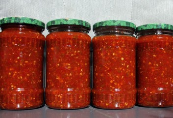 Red and green chili peppers sauce preserved in vinegar, for winter. Chili in a jar