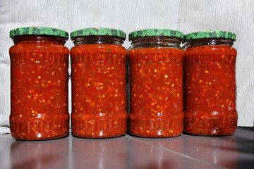 Red and green chili peppers sauce preserved in vinegar, for winter. Chili in a jar