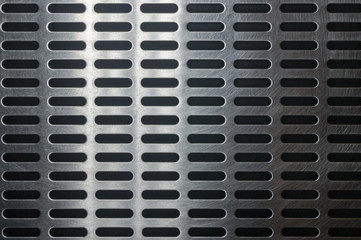 stainless steel grating with oblong holes, close up.