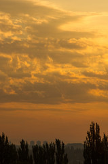 Landscape with dramatic light - beautiful golden sunset with saturated sky and clouds.