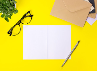 Creative workspace with envelopes on yellow background.