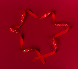 Wavy polka dot red ribbon on red background.