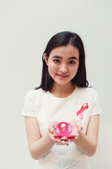 Asian young woman holding pink ribbon, breast cancer awareness, October pink concept