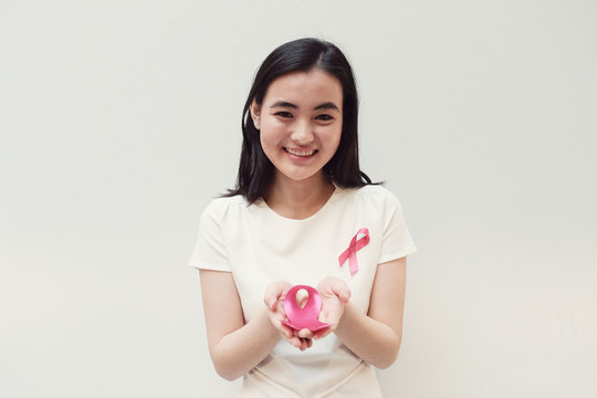 Asian young woman holding pink ribbon, breast cancer awareness, October pink concept