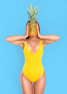 Slender woman with pineapple on a blue background