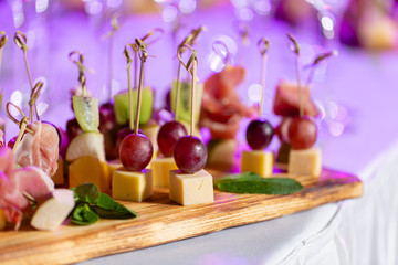Light snacks in a plate on a buffet table. Assorted mini canapes, delicacies and snacks, restaurant food at event. A gala reception. Decorated delicious table for a party goodies.