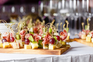 Light snacks in a plate on a buffet table. Assorted mini canapes, delicacies and snacks, restaurant...