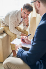 Portrait of depressed mature man sharing his mental problems with psychiatrist during therapy...