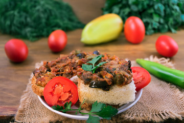 A portion of vegetable stew, laid on white bread, decorated with parsley and tomato slices.