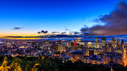 Obraz premium Beautiful Montreal at sunrise or sunset. Amazing view from Belvedere with colorful autumn leaves. Stunning panorama of Montreal downtown skyline in the fall night time.