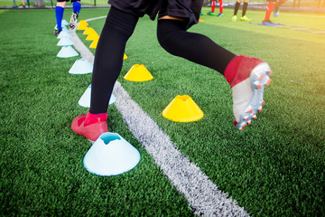 Young boy soccer players Jogging and jump between many marker cones. © Koonsiri
