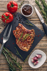 Grilled veal chop with vegetables on rustic table. Top view