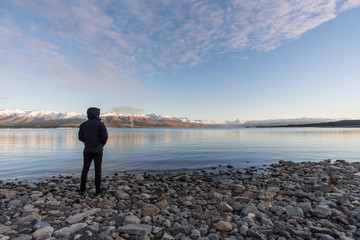 Man standing on rocks looking at Mt Cook, New Zealand