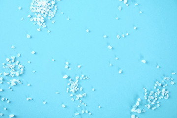 Crystals of large sea salt on a blue table.