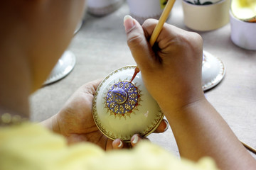 artist painting benjarong ceramic ware