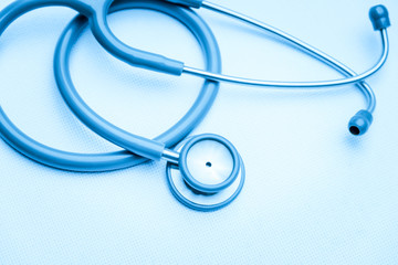Top view of gray stethoscope medical equipment on white canvas. instruments device for doctor. medicine concept