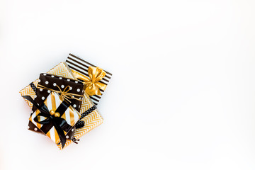 Top view of a heap of gift boxes in various black, white and golden designs. A concept of Christmas, New Year, birthday celebration event.