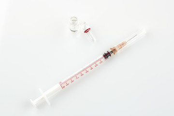 Naklejka premium Ampoule with medicine and syringe on white background