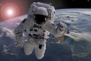 astronaut flying in outer space near planet earth doing some work near space ship, elements of this...