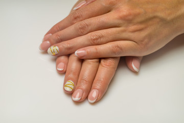 French manicure and nail gel Polish. The decoration of the nail white and gold decor. Top view Close-up photography