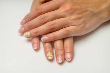 French manicure and nail gel Polish. The decoration of the nail white and gold decor. Top view Close-up photography