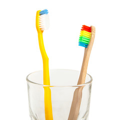 Set of toothbrushes in glass isolated on white background. Concept toothbrush selection, bamboo eco-friendly and plastic