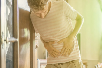 young man holding touching stomach, suffer from strong stomache f