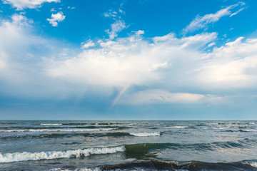 Rainbow over the sea after rain