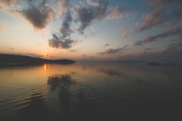 Fototapeta na wymiar Calm Sea Water, Cloudy Sky and Beautiful Sunrise Morning