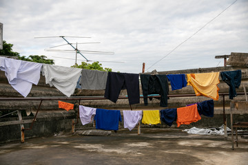 a set of primary colored T-shirts hanging on a clothesline on a  white sky