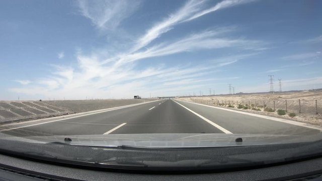 Driving car on Highway in gobi desert ,POV front windshield